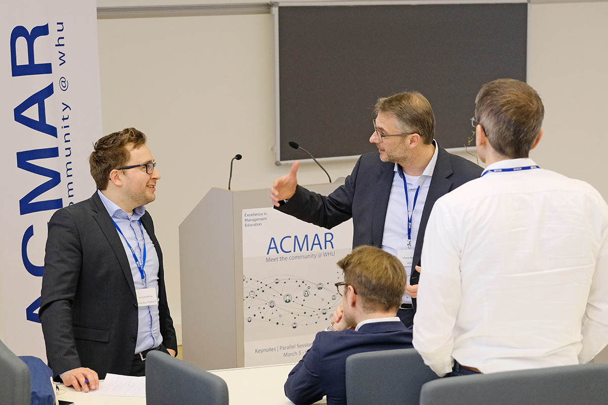 Marko Reimer is in conversation with three people at the IMC' ACMAR conference