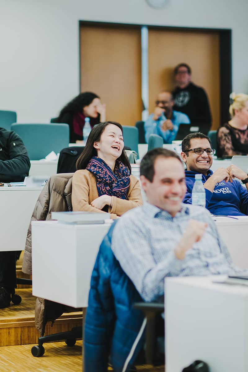 Laughing EMBA students listen to a lecture