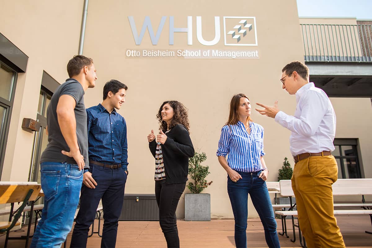 Fünf MBA Studenten, die über Studium bei WHU diskutieren. 