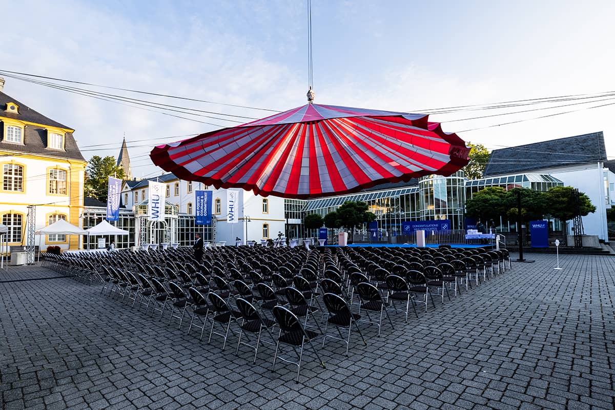 A red and blue striped canopy over empty seats on the Burgplatz Campus Vallendar